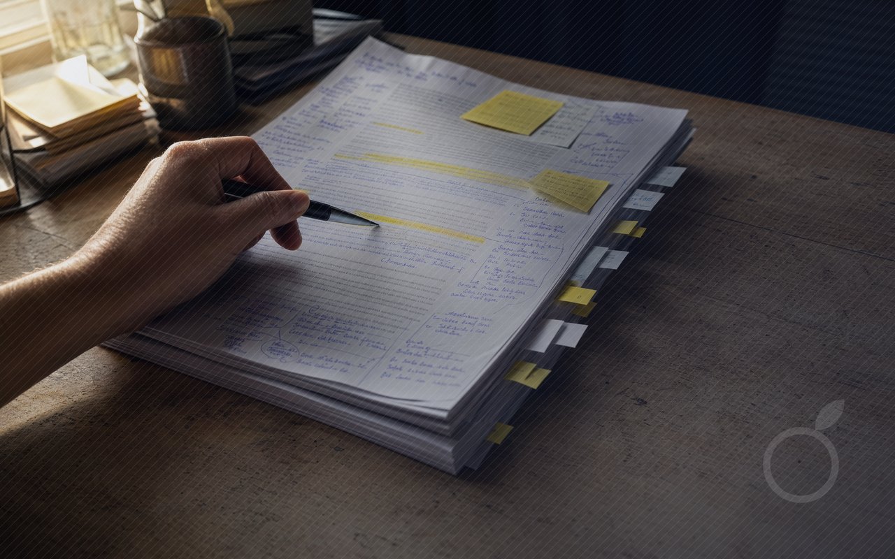 Main au stylo sur un rapport épais couvert de post-it, illustrant l'analyse approfondie rendue plus fiable et moins chère avec Claude Fable 5.1.